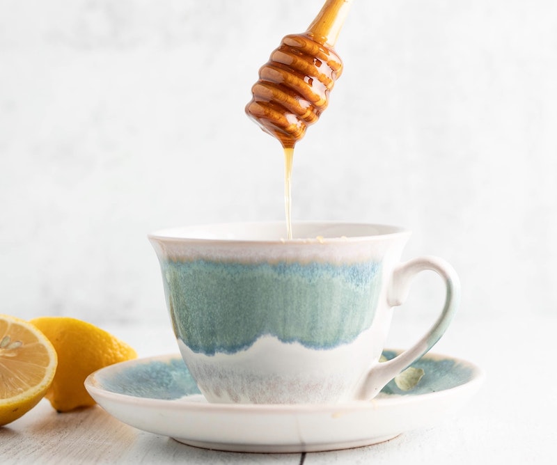 adding honey to coffee