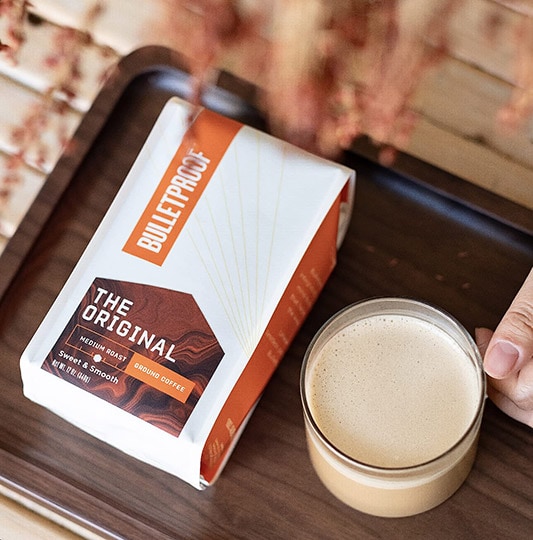 bulletproof coffee original pack next to a cup of coffee on tray