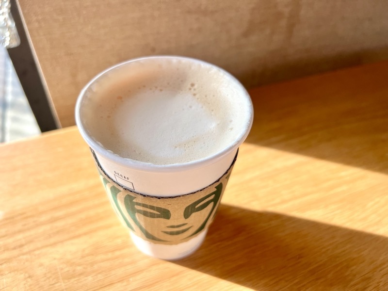 Starbucks Flat White in paper cup on table_Kate